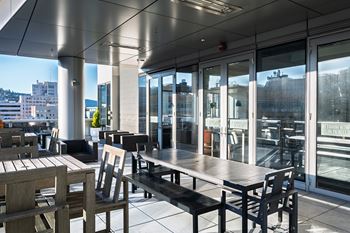 Outdoor terrace overlooking director park, with a fireplace feature and grilling station